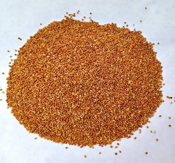 Red millet grains from Countrywide displayed in a close-up shot, showcasing their vibrant color and small, round shape.